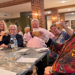 a group of people holding drinks at a table